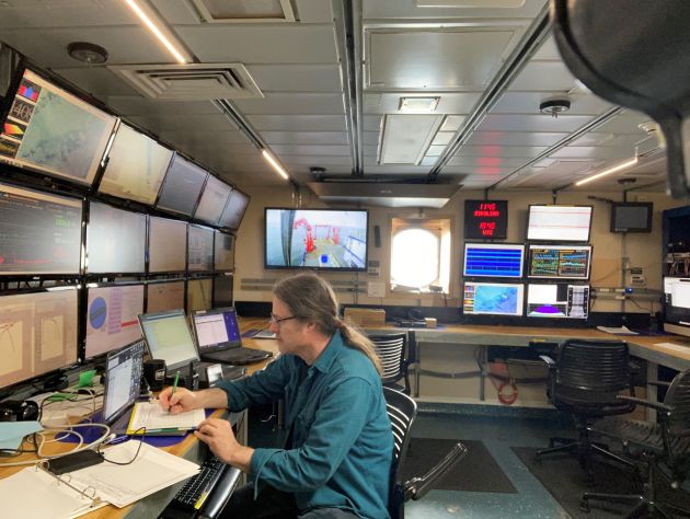 Man aboard ocean research vessel conducting scientific experiments 