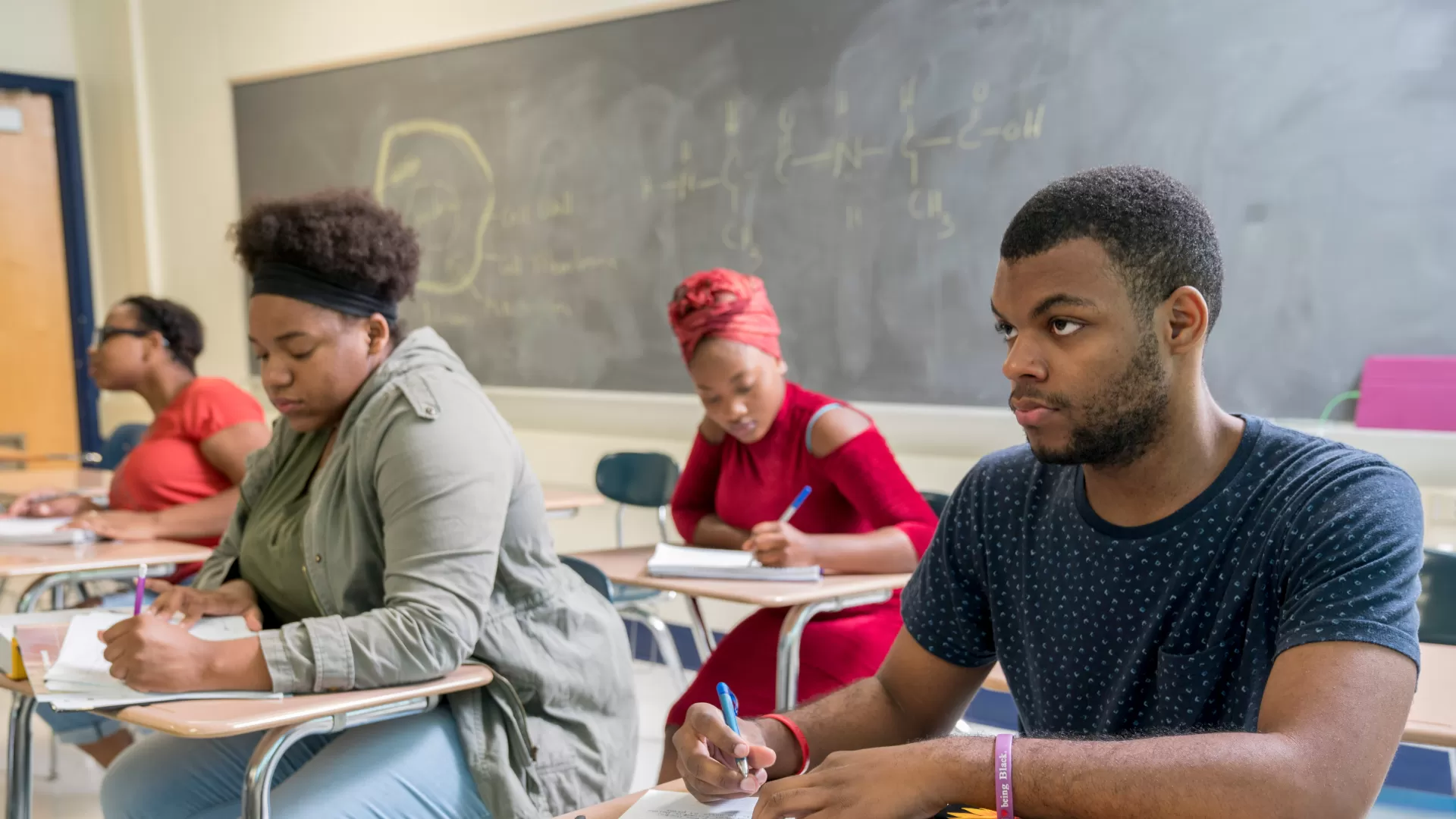 College students sitting at desks in a classroom.