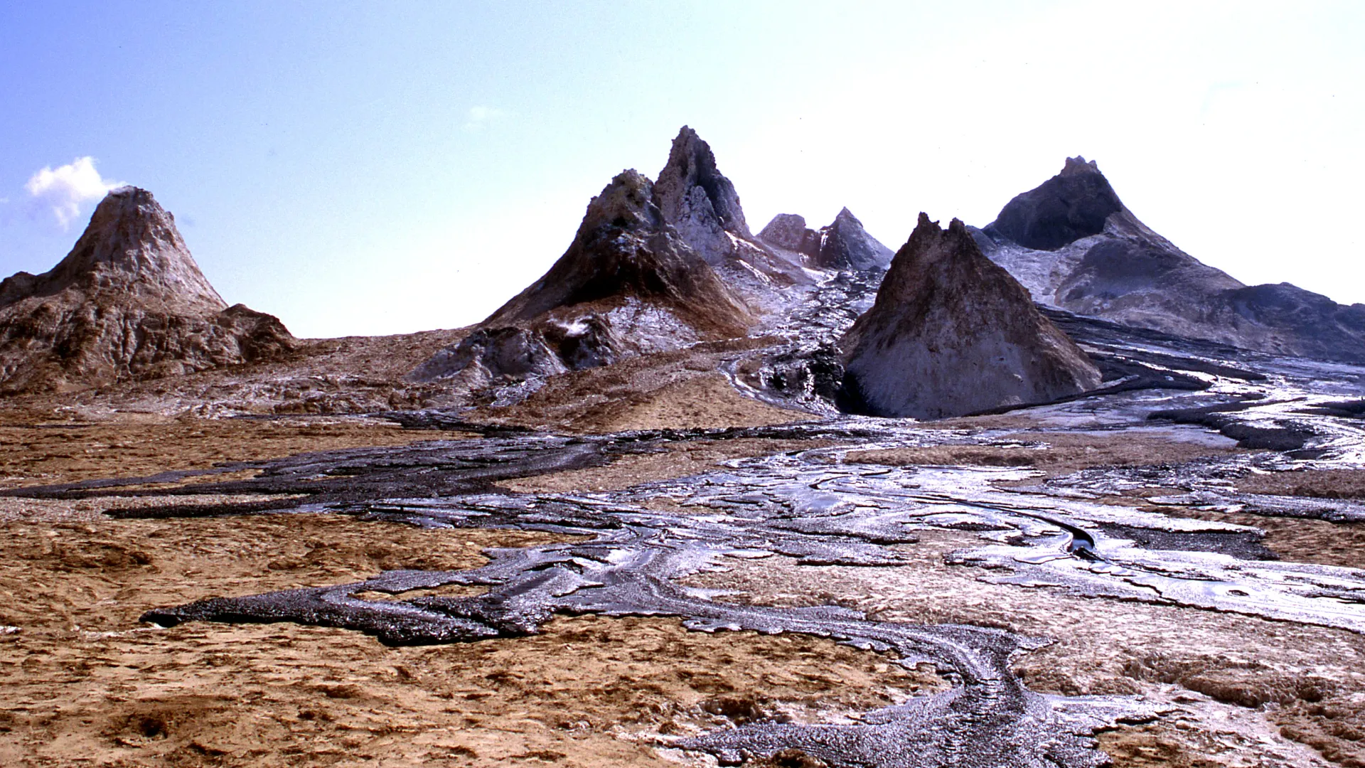 Sharp rock peaks with black lava flows in the foreground.