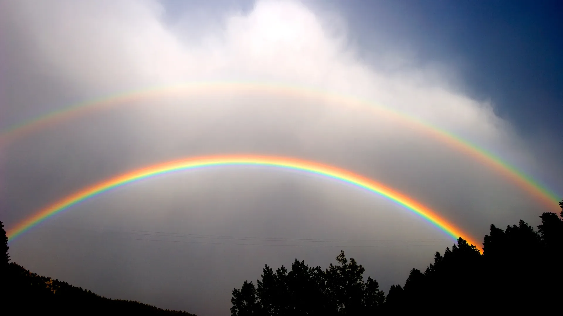 A double rainbow in a gray sky.