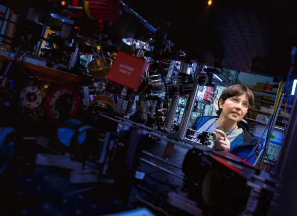 A complex piece of computing equipment with a researcher in the background