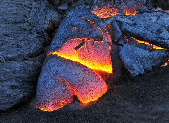 Glowing lava surrounded by cooled lava.