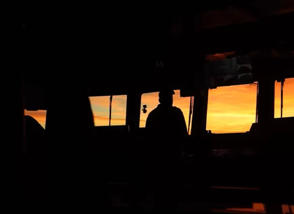 Silhouettes of researchers inside a research ship.