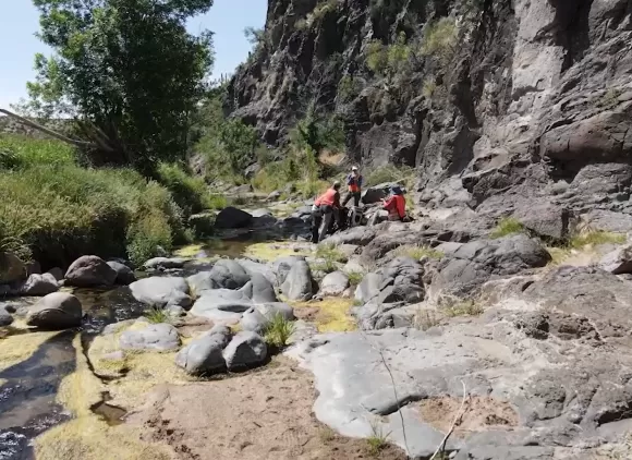 Researchers gathered on rocks on the edge of a creek.