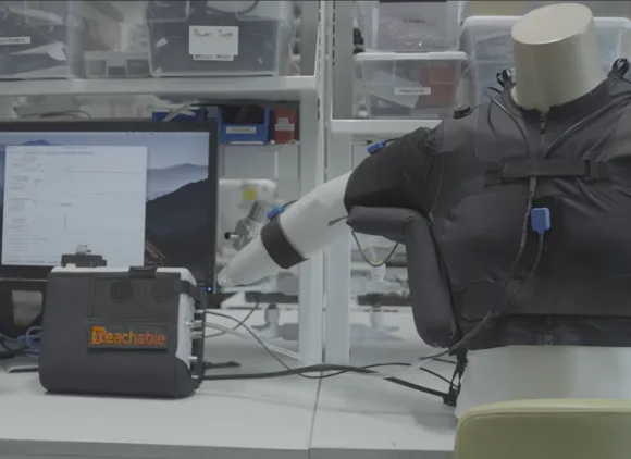 In a laboratory, a mechanical vest moves the arm of a mannequin.