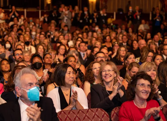 A group of applauding people in a theater.
