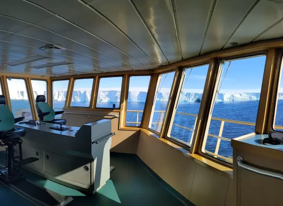 View of ice sheets through windows on the bridge of a ship.