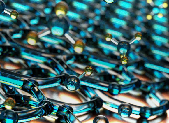 Two layers of a lattice of translucent blue beads connected in hexagonal rings with some blue and yellow beads floating free from the matrix.