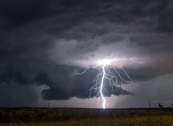 A cloud-to-ground lightning strike during a nighttime thunderstorm in the Midwest