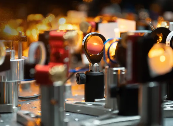 Close-up view of various mounted optical lenses that are part of the laser system in the Will lab at Columbia University.