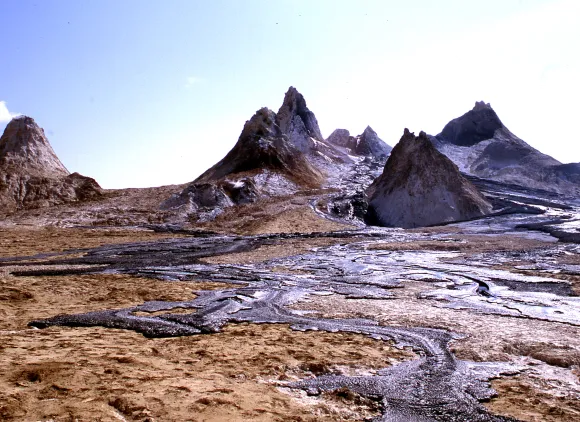 Sharp rock peaks with black lava flows in the foreground.