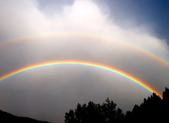 A double rainbow in a gray sky.