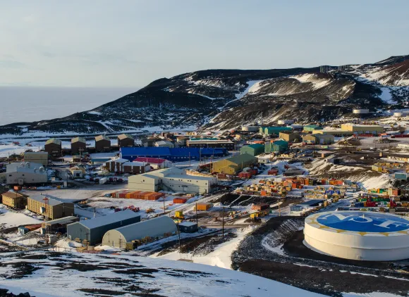 A cluster of buildings on a stark, snow-covered landscape
