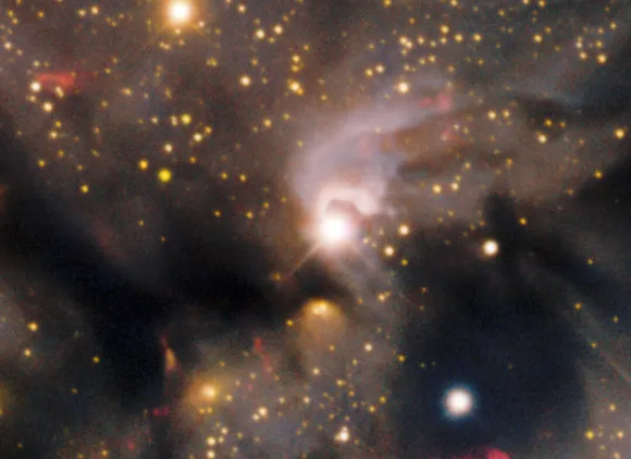 Glowing white and yellow and red objects on a black and gray hazy background.