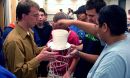 A group of students test the strength of a straw tower they built.
