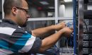A student practices hands-on router configuration in a classroom convergence lab