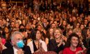 A group of applauding people in a theater.