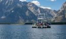 A boat in a body of water with a mountain background.