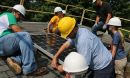 Students in hard hats working on solar panel.