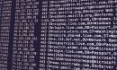 A dark computer monitor displays strings of data.