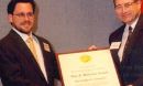 Dr. Christopher C. Cummins and Neal Lane, NSF Director holding framed plaque award