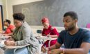 College students sitting at desks in a classroom.