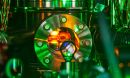 A shiny metal vacuum chamber with red light emanating from inside.