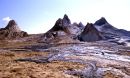 Sharp rock peaks with black lava flows in the foreground.