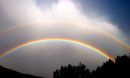 A double rainbow in a gray sky.