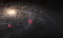 An illustration of many faint brown dwarf stars surrounding a galaxy. The galaxy occupies most of the image as a fuzzy oval disk.