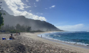 ocean and mountain landscape with people sitting on the beach