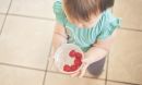 baby holding a bowl of berries