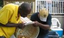 Two men dumping shrimp and corn from a food basket