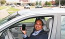 Photo of researcher Ram Dantu holding smart phone in his car.