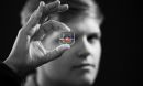 Rachel Young, a graduate student, holds up the new eye-on-a-chip device