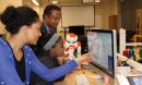 Photo of Andrew Williams instructing girls using the Choreographe visual programming environment