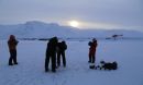 an ice auger is used to drill a borehole through Isortoq River