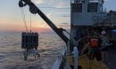 Researchers recover a CTD instrument used to collect water samples from multiple depths in the ocean.