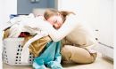 Photo of woman resting her head on basket of laundry.