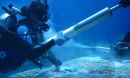 Scientists retrieve a coral core piece during an underwater drilling process.
