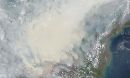 thick gray smoke hovers over the Southeast Asian island of Borneo