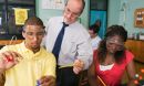 Photo of a teacher with two students carrying out a science experiment.