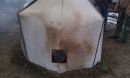 A tent-like kiln over woody waste material