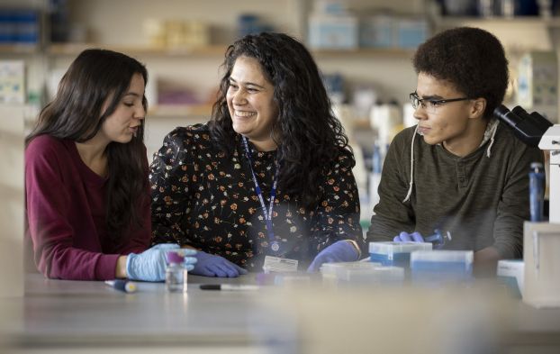 A professor in a lab with two students