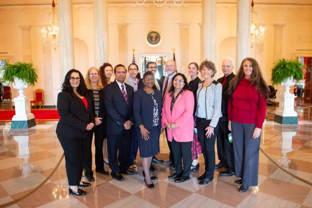 A group of people stand in a lobby area.