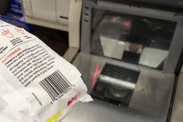 A shopper scans a barcode at a self-checkout station at a grocery store