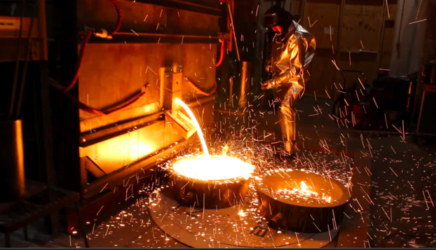 Workers remove molten iron from a pilot scale facility at Boston Metal, in Woburn, Massachusetts