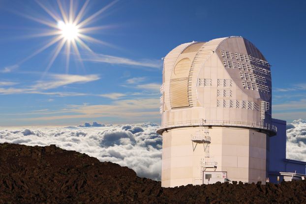 A large telescope facility on the summit of a mountain above the clouds.
