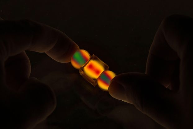 3D photoelastic particles light up and change color under force