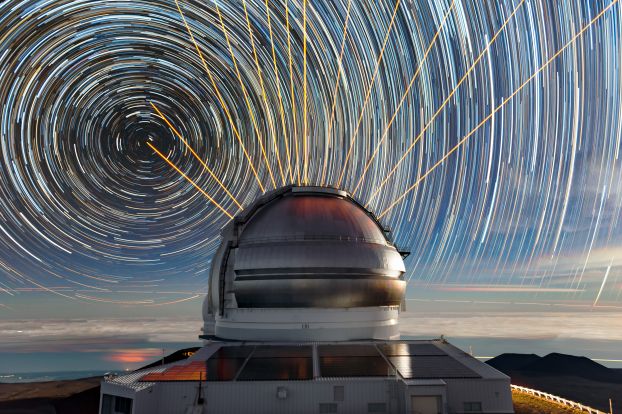 A timelapse still shot of concentric circles representing stars in the sky are seen above the Gemini North telescope.